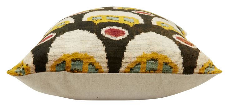 a decorative pillow with an unusual design on the front and back, sitting on a white surface