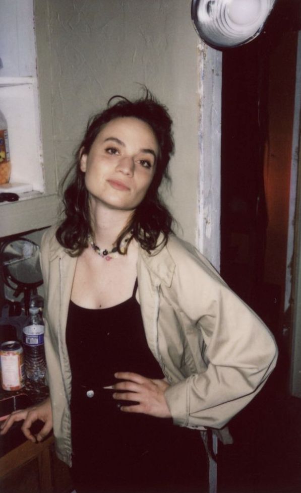 a woman standing in a kitchen with her hands on her hips and looking at the camera