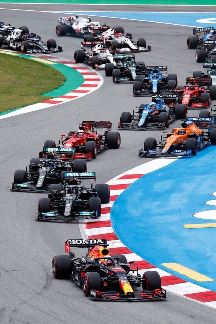 a group of cars driving down a race track