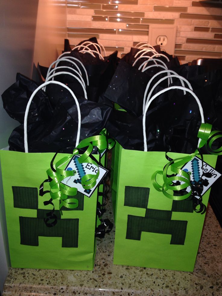 two green bags with black bows on them sitting on a counter top next to each other