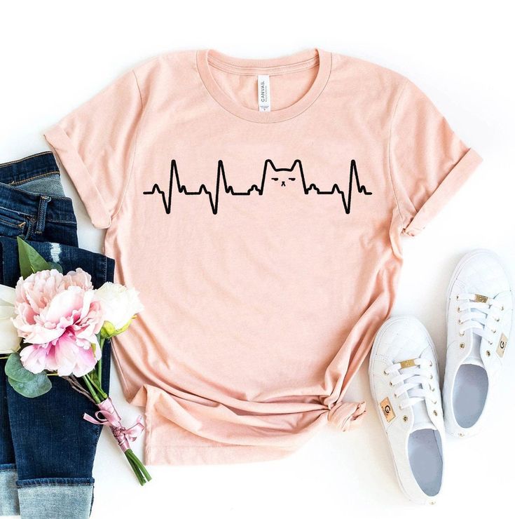 a t - shirt with the word heartbeat on it next to some flowers and shoes