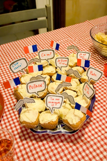 a table topped with lots of cupcakes covered in frosting