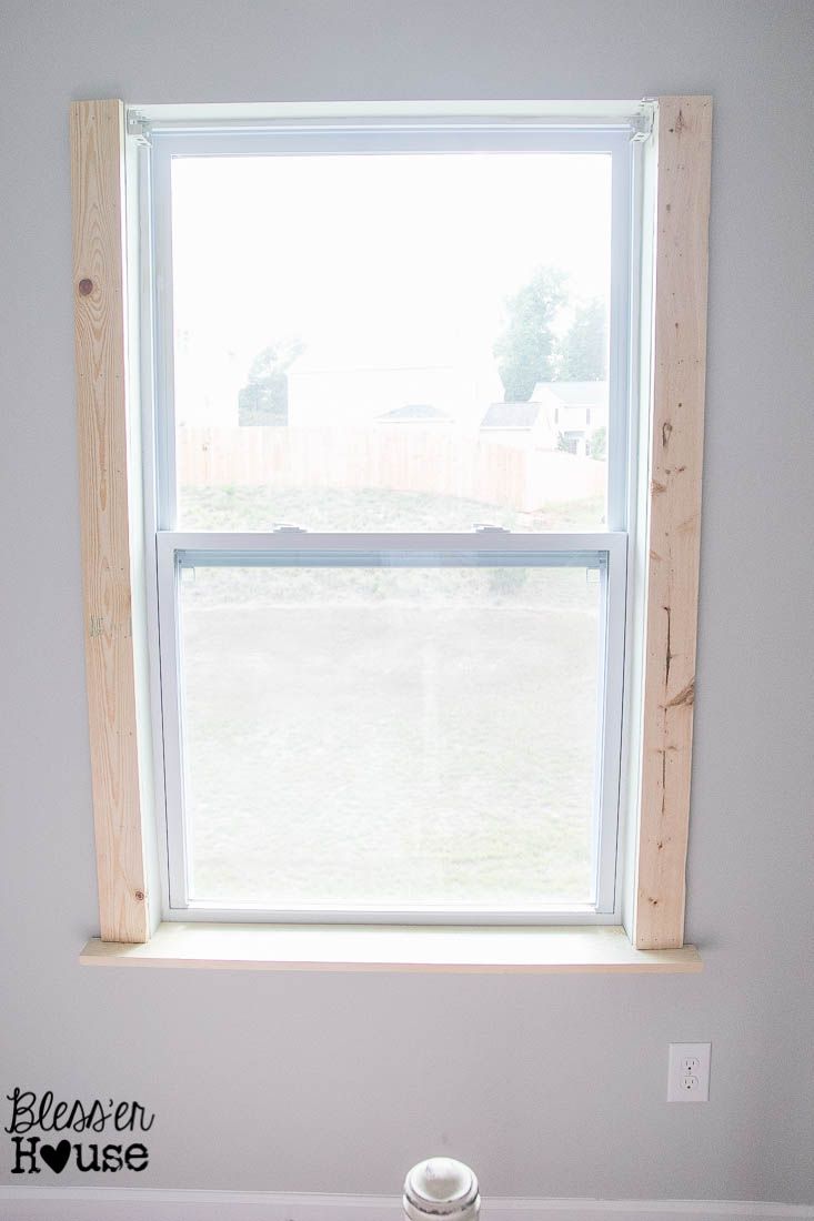 a bathroom with a toilet and window in the corner, all white paint on the walls