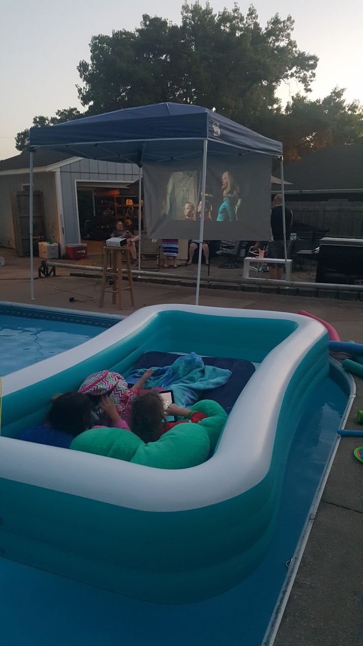 an inflatable pool with people sitting on it and watching tv from the back