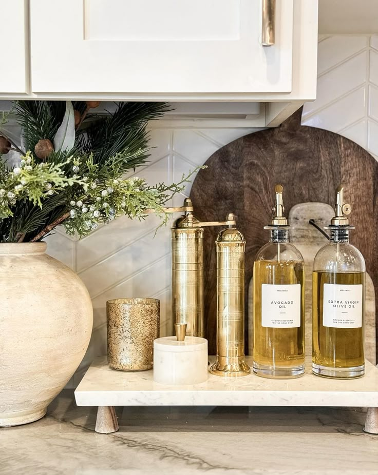 some bottles are sitting on a shelf in the kitchen next to a potted plant