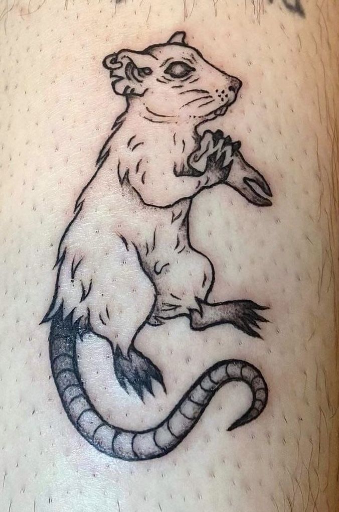 a rat tattoo on the back of a man's leg