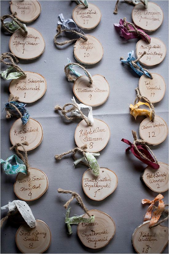 a table topped with lots of different types of rings and tags on wooden discs covered in writing