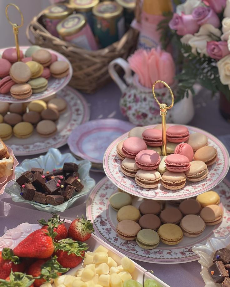 a table topped with lots of different types of desserts and pastries on plates