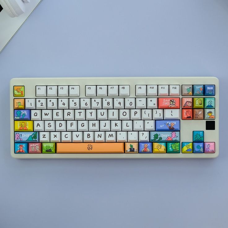 a white keyboard with colorful keys on it sitting on a blue surface next to a computer mouse