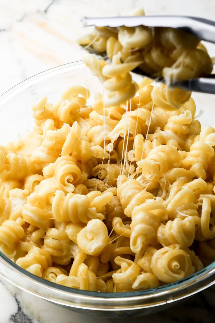 a glass bowl filled with macaroni and cheese