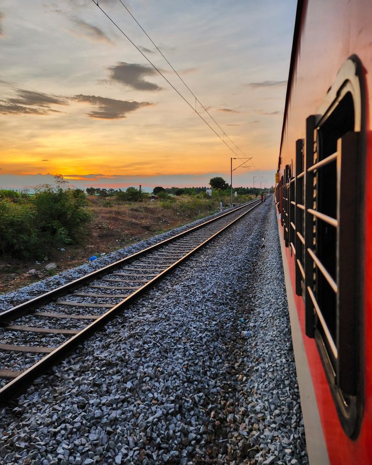 a red train traveling down tracks next to the ocean