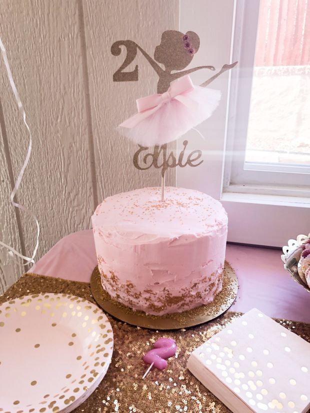 a pink cake sitting on top of a table