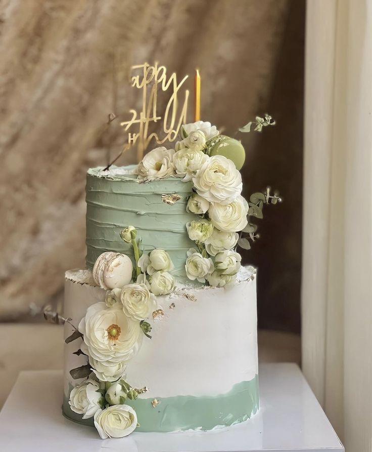 a three tiered cake with flowers and candles