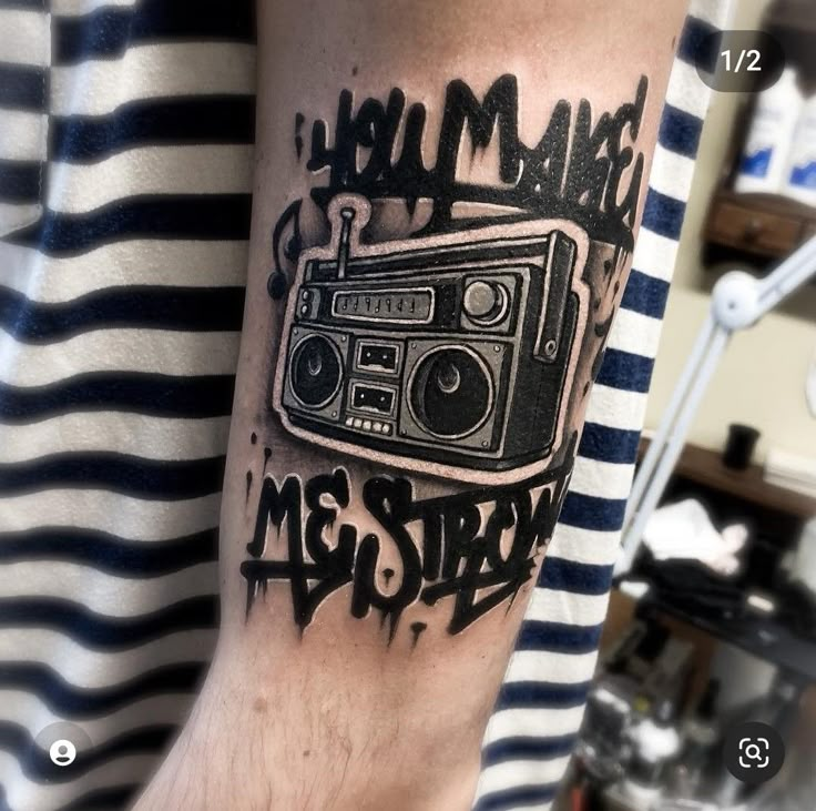 a man's arm with a radio on it and the words make me strong written in black ink