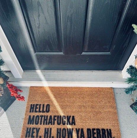 a door mat that says hello, mohafuka hey, hi, now ya derrid