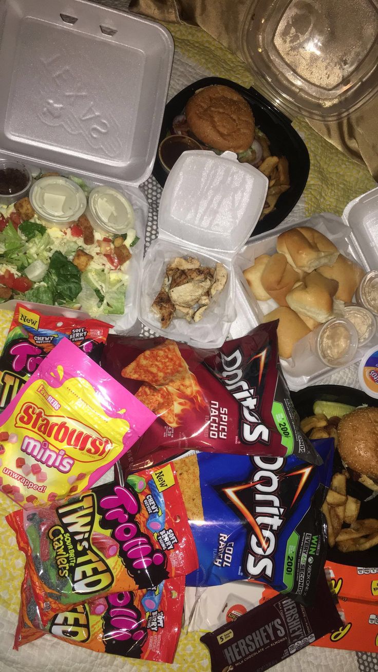 an assortment of food is sitting on a bed next to other foods and condiments