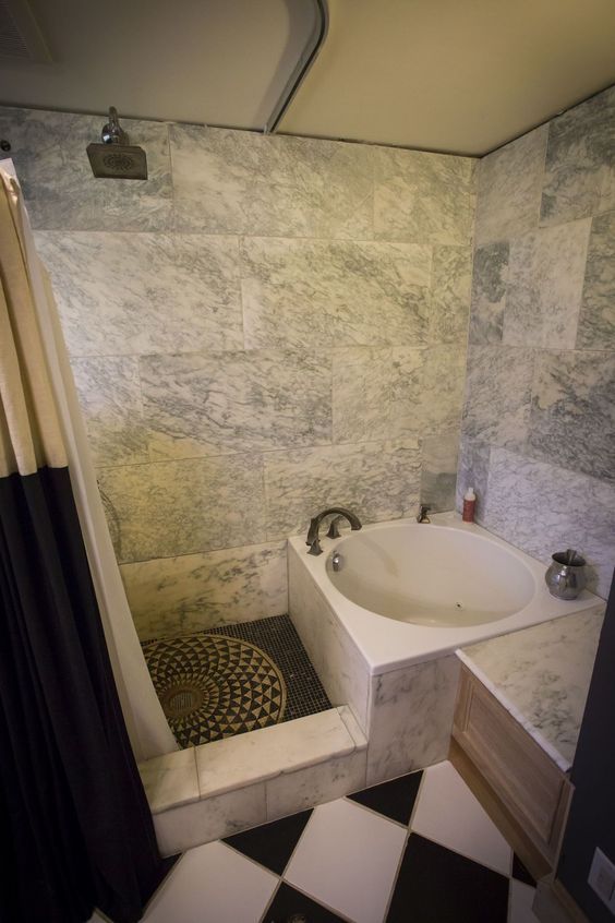 a bath tub sitting next to a black and white checkered floor