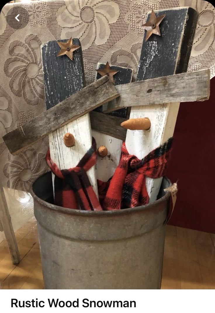 a bucket filled with wooden snowmen sitting on top of a table