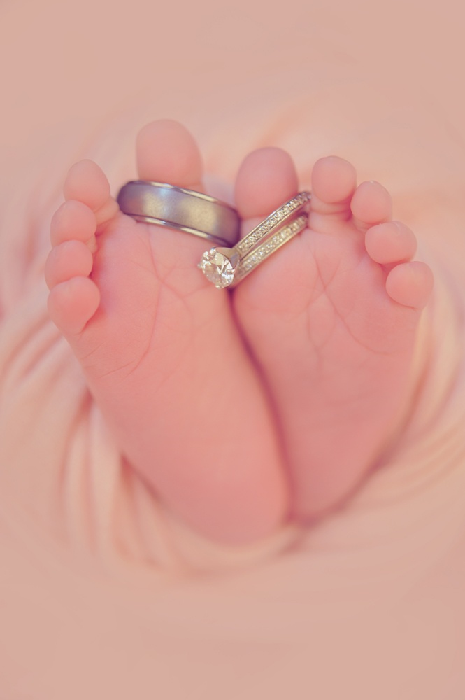 a baby's feet with two wedding rings on them