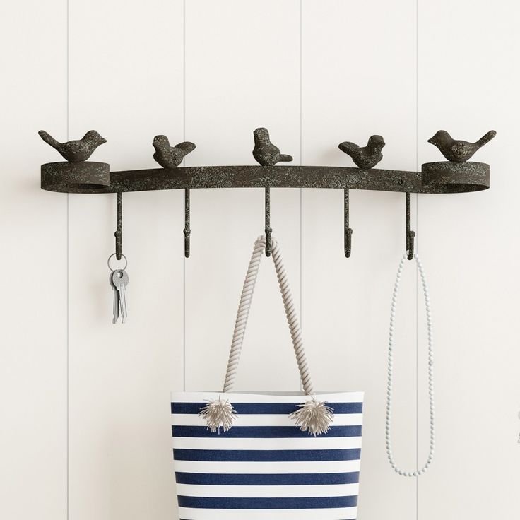 a blue and white striped tote bag hanging from a hook with birds on it