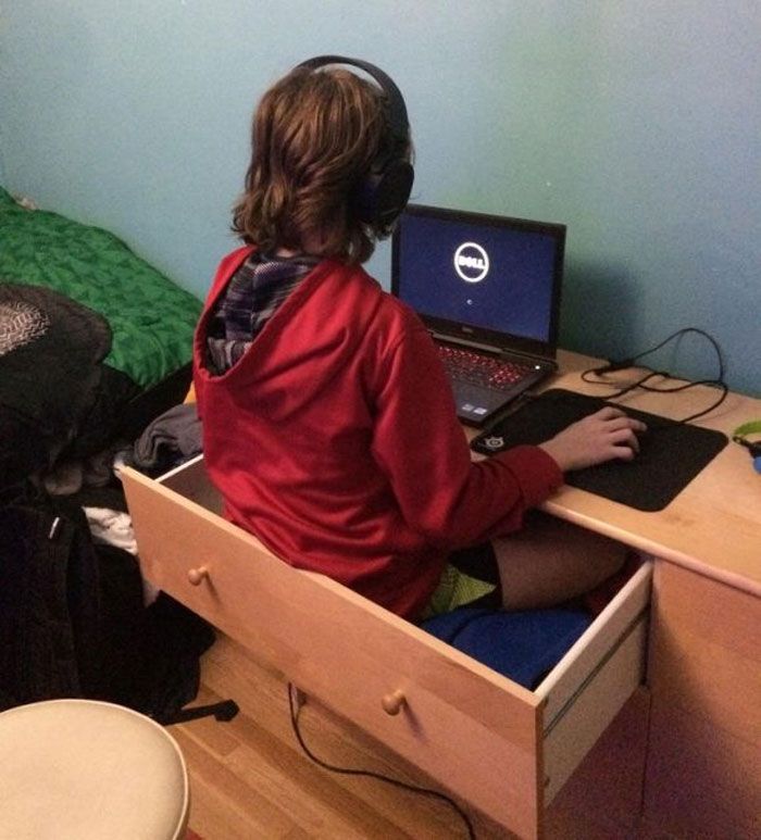 a person sitting at a desk with a laptop and headphones in front of them