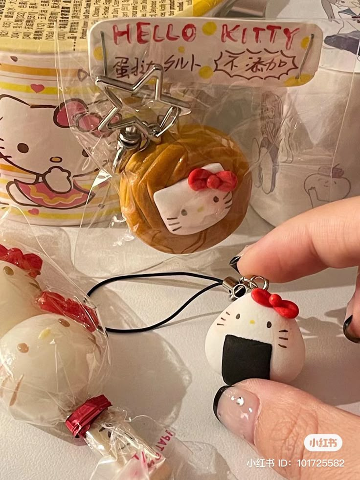 the hello kitty keychain is being held by someone's hand