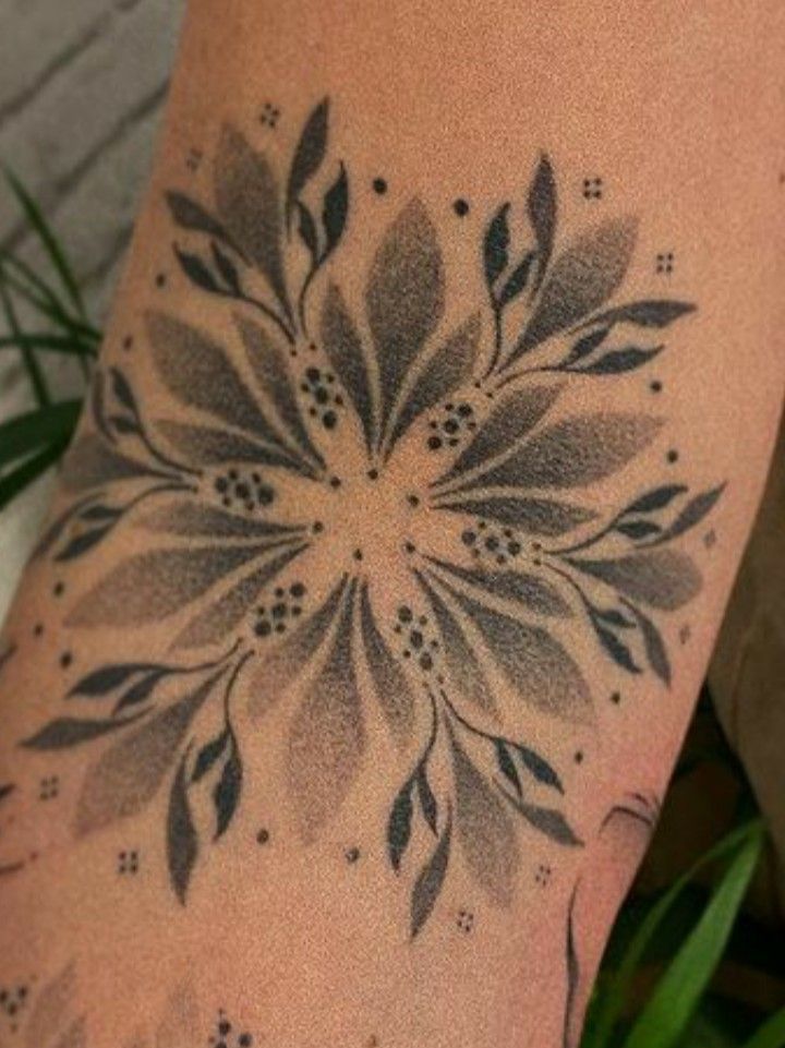 a woman's arm with a flower tattoo on the back of her leg,