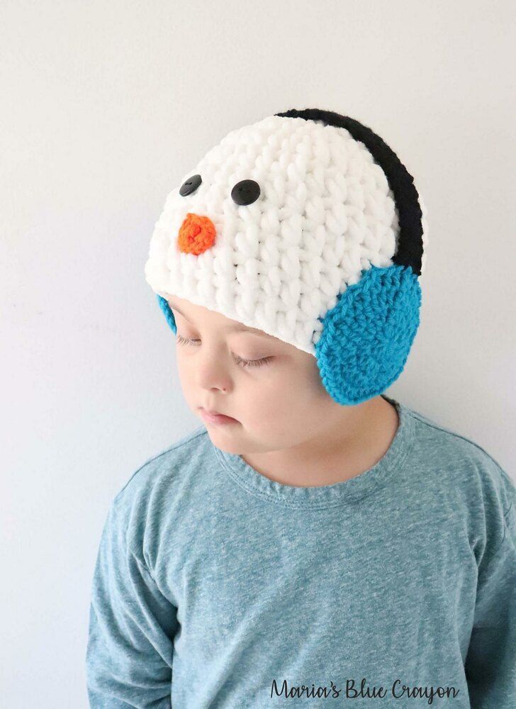 a young boy wearing a crocheted penguin hat