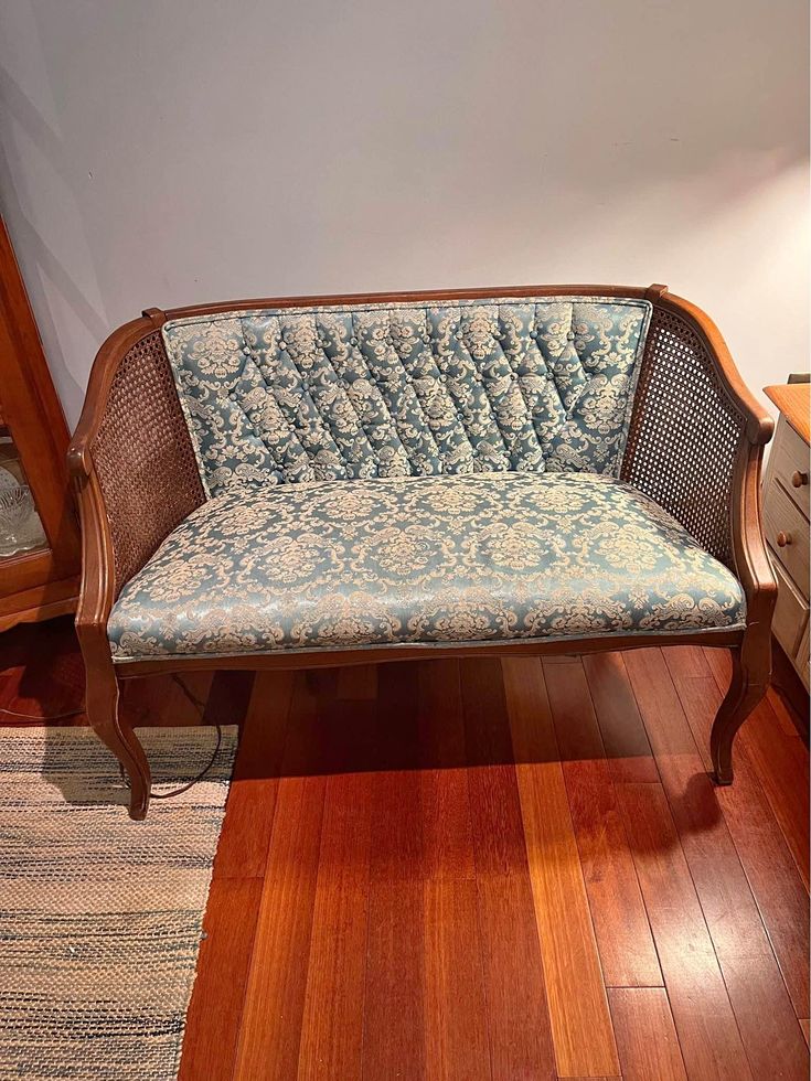 a wooden couch sitting on top of a hard wood floor