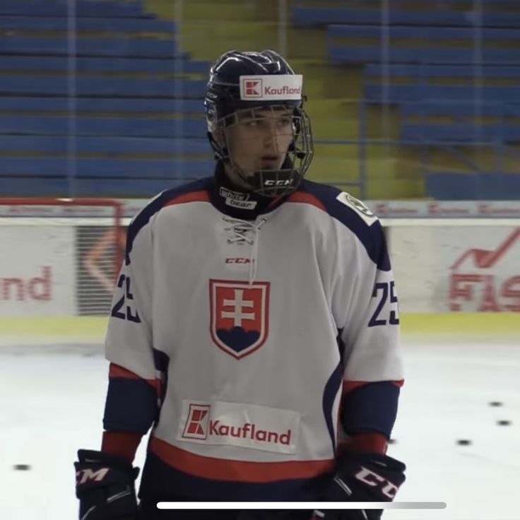 a hockey player standing on the ice with his hands in his pockets and wearing a helmet