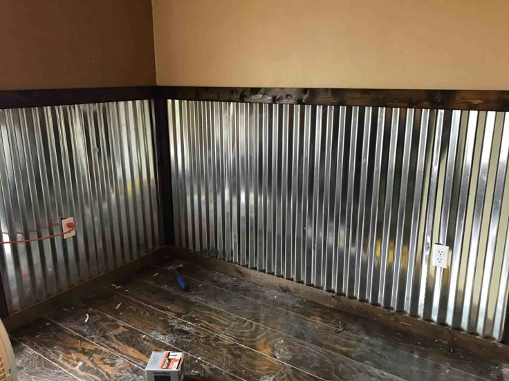 the inside of a room that is being remodeled with metal slats and wood flooring