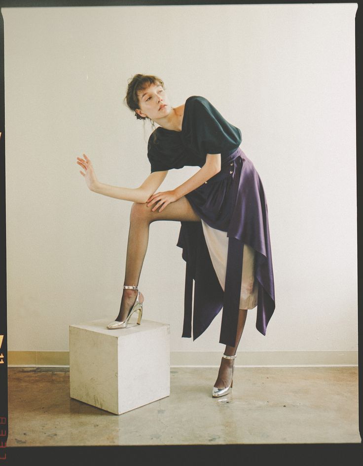 a woman sitting on top of a white box