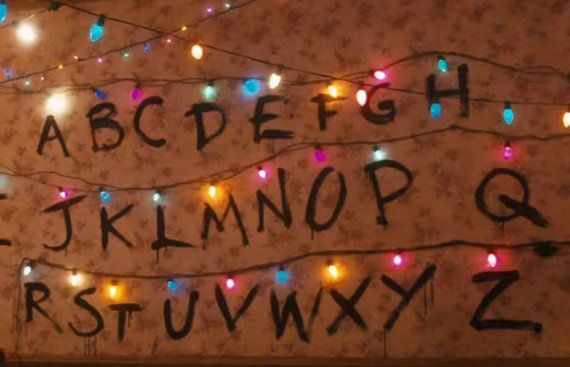 the letters and numbers are decorated with christmas lights in black ink on an old wall