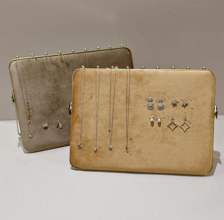 two purses with jewelry on them sitting next to each other in front of a wall