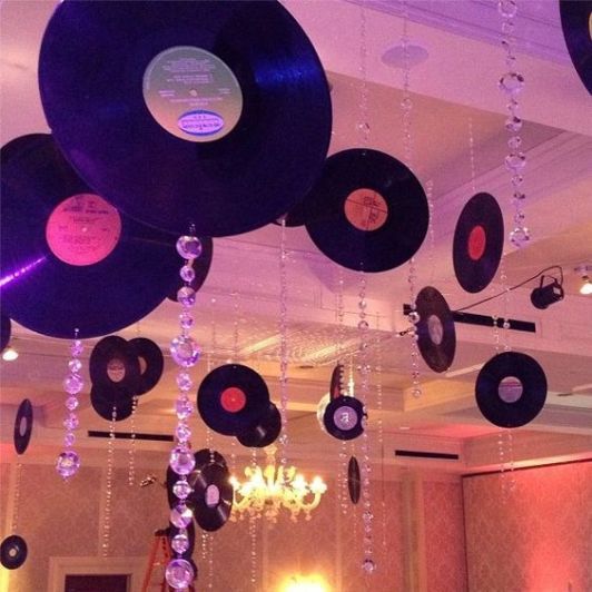 a room filled with lots of different types of records hanging from the ceiling and chandelier