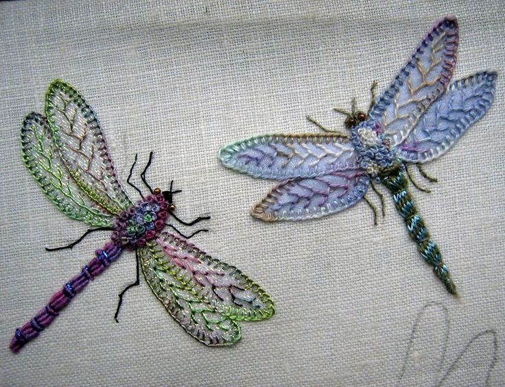 three dragonflys sitting on top of a piece of cloth next to each other