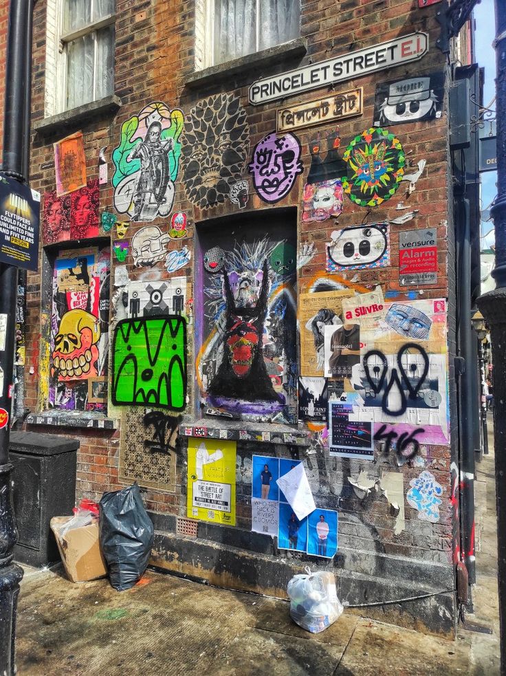 a brick building covered in graffiti and stickers