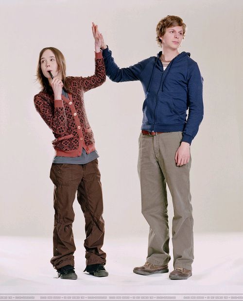 two people standing next to each other in front of a white background