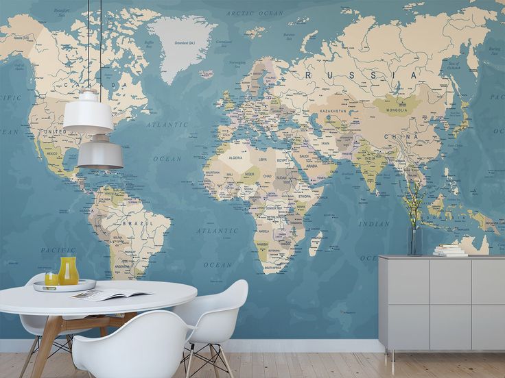 a dining room with a large world map on the wall and white chairs in front of it