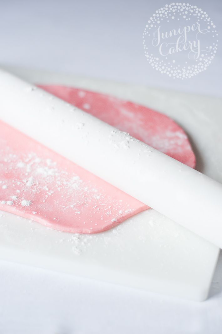 a pink and white ice cream bar sitting on top of a white counter next to a plastic spoon