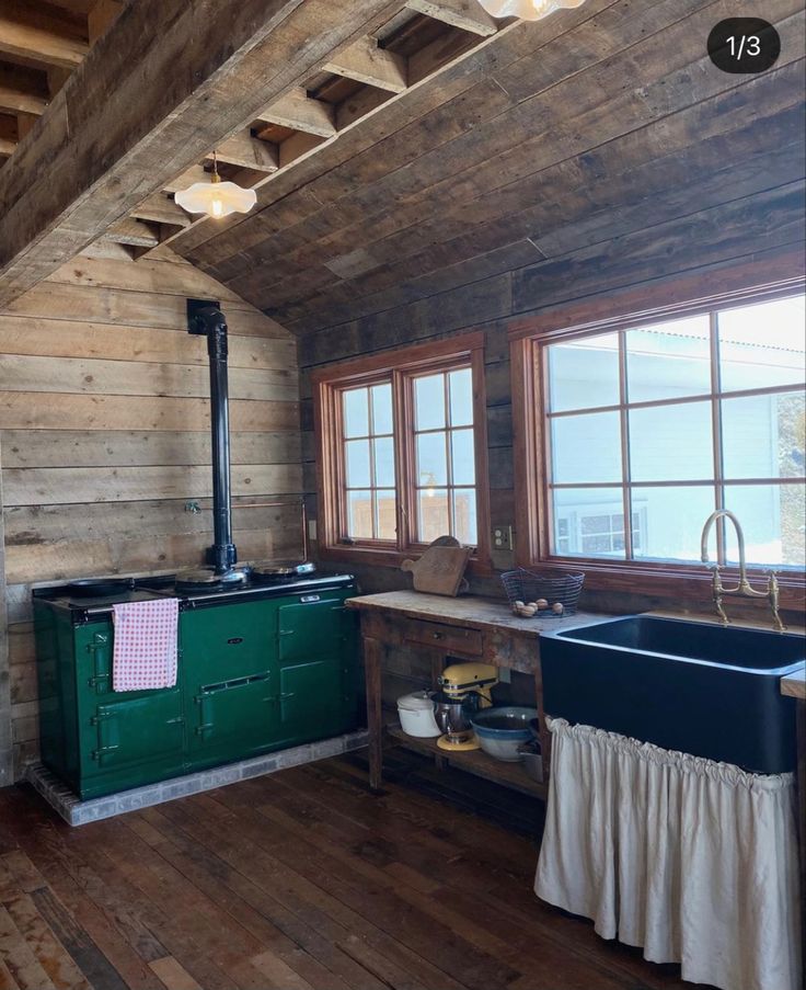 an old fashioned kitchen with wooden walls and flooring is shown in this rustic cabin