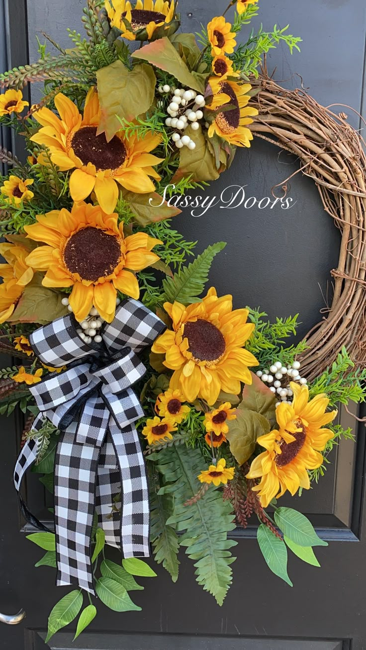 a wreath with sunflowers and greenery on the front door