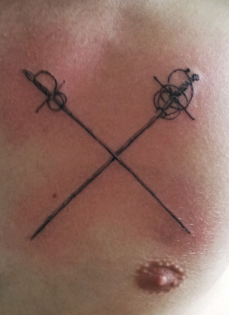 two crossed swords on the back of a man's chest with no shirt underneath