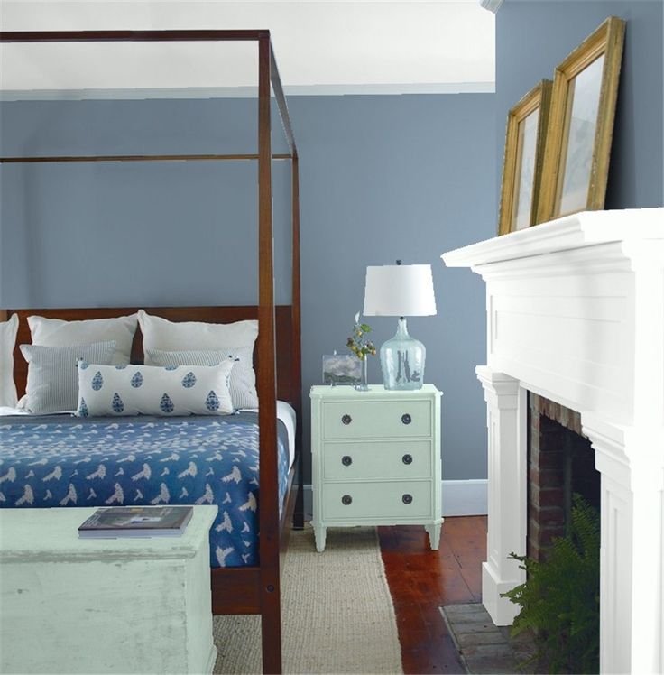 a bedroom with blue walls and white furniture