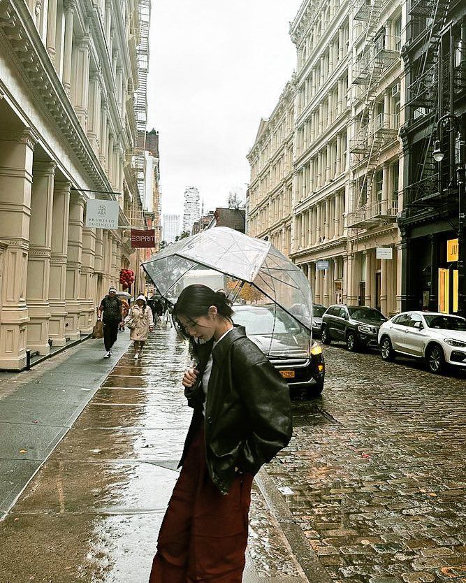 a man is standing in the rain with an umbrella