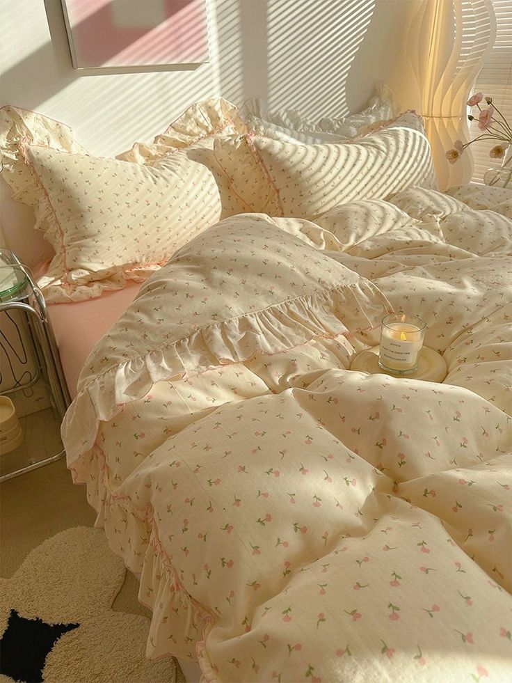 an unmade bed with white sheets and pink pillows