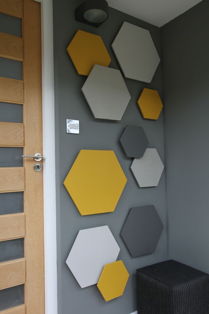 the wall is decorated with hexagons and other shapes in yellow, gray, and white