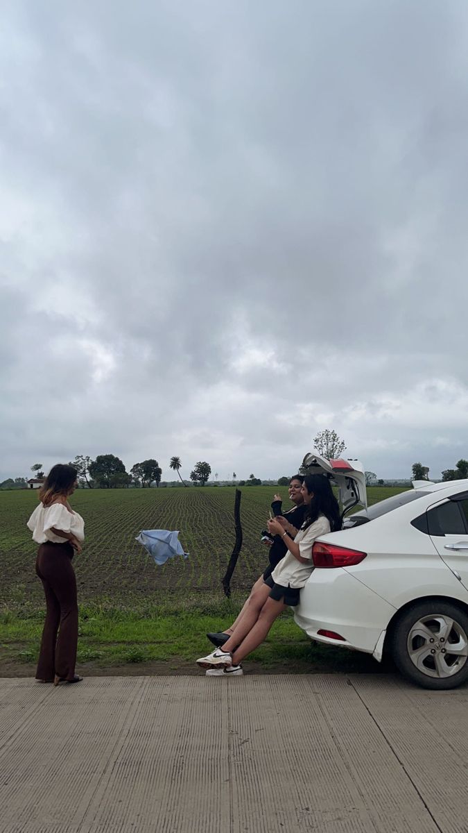 two people sitting on the back of a car