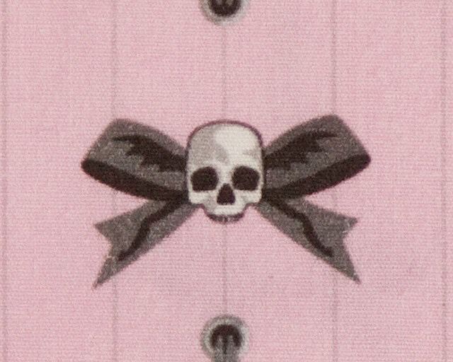 a pink shirt with a skull and crossbones on the front, tied in black ribbon