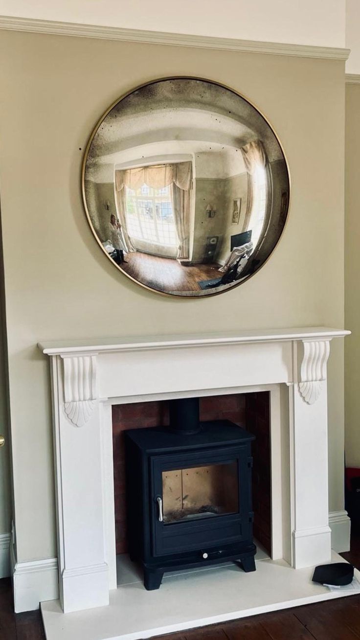 a fireplace with a mirror on the wall above it